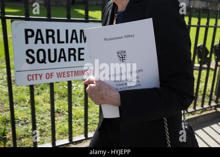 London UK. 5th April 2017 A  Woman leaves Westminster Abbey with a copy of the programe after attending a service of hope at Westminster Abbey following the terror attack in Westminster. Stock Photo