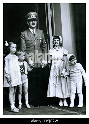 Adolf Hitler in uniform with swastika armband posing outside his alpine chalet in Berchtesgaden on his 50th birthday with a group of children from high ranking Nazi officials April 20th 1939 Stock Photo