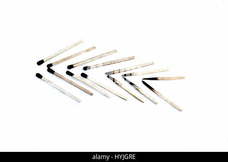 Burned matchsticks with abstract shape isolated on white. Stock Photo
