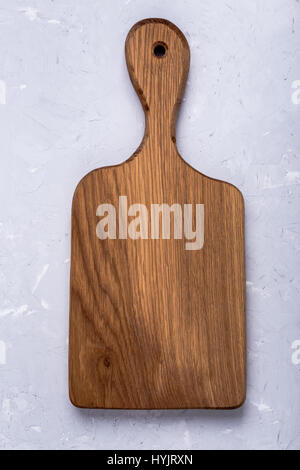 Oak wood cutting board on light gray color plaster texture background,  top view with copy space Stock Photo