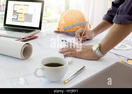 Interior designer discussing data and digital tablet and computer laptop with business document and graphics design diagram on wooden desk as concept Stock Photo
