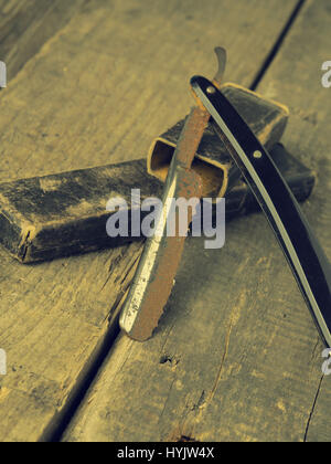 Old and rusty razor on a rustic workbench with space for text or image Stock Photo