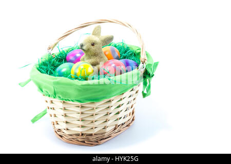 Basket filled with green cloth and fake grass with Easter Bunny and six hand painted chicken eggs Stock Photo