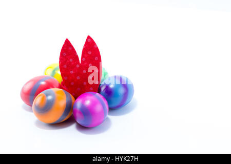 Six hand colored easter eggs with red Easter Bunny ears in the middle of them Stock Photo