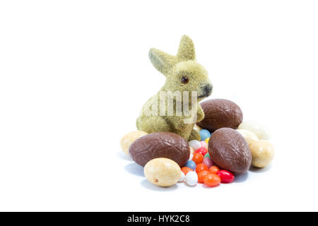 Easter bunny with different kinds and colors of chocolate easter eggs isolated in white background Stock Photo