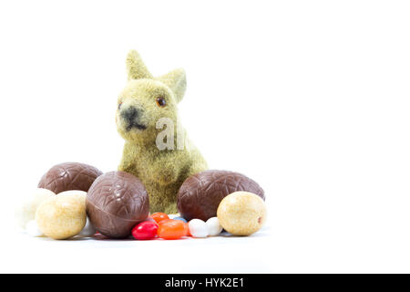 Easter bunny with different kinds and colors of chocolate easter eggs isolated in white background - close Stock Photo