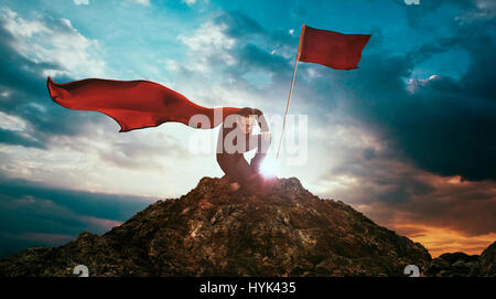 Businessman in a suit and cape hero on top of a mountain,Business Success concept. Stock Photo