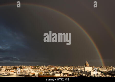After a downpour, a huge rainbow appeared in the darken early evening sky above Seville Old Town, Spain. It was seen from the Metropol Parasol located Stock Photo