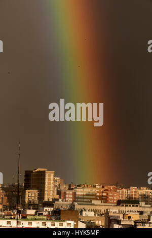 After a downpour, a huge rainbow appeared in the darken early evening sky above Seville Old Town, Spain. It was seen from the Metropol Parasol located Stock Photo