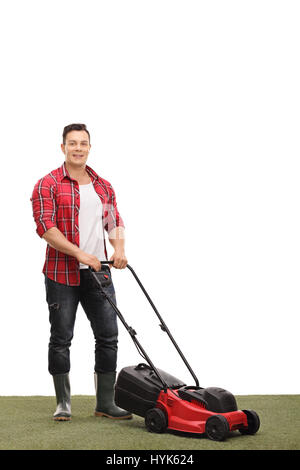 Full length portrait of a young gardener with a lawnmower isolated on white background Stock Photo