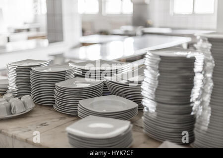 White empty clean dishes on the restaurant kitchen table Stock Photo