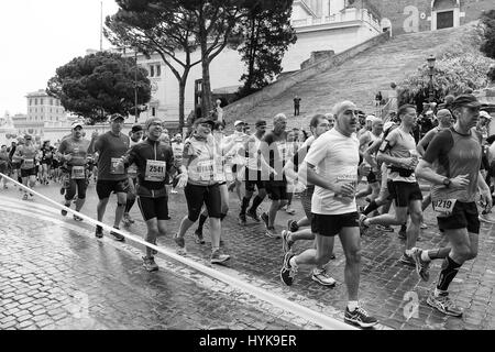 Rome, Italy - April 2, 2017: Athletes participating at the 23rd Rome marathon run through the street circuit passing the Capitol, seat of the Municipa Stock Photo