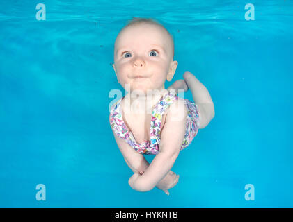 A picture of Sophia, 4 months old, at an underwater photo shoot at Hydro at the Barn in Lancashire. SWIMMING before they can walk these little bathing beauties have been photographed underwater by a British photographer. Utilising their natural amphibious reflex, these babies, aged from just three months old, held their breath as they were released underwater by professional baby swim instructors.  Photographs show the hilarious expressions on the faces of the little nippers. London based underwater photographer Lucy Ray (35) from Starfish Underwater Photography took these pictures across vari Stock Photo
