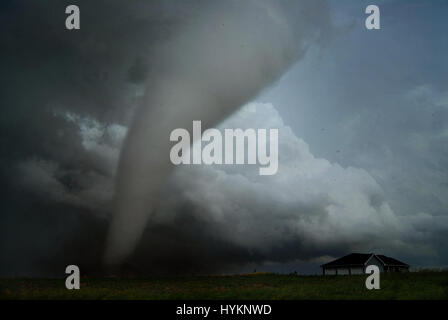 TORNADO ALLEY, USA: Pleasanton tornado appraoching a house. THE DEADLIEST weather events have been captured on camera by one lightning quick photographer. Incredible photographs show extreme weather from America’s Tornado Alley, renowned for the frequency of its storms. From terrifying lightning bolts to all-encompassing tornados, these pictures manage to capture to ferocity and atmosphere of these natural phenomena. Stock Photo