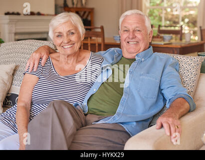 Couple of relaxed seniors sitting on their couch Stock Photo