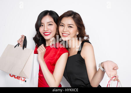 Two happy attractive young women with shopping bags on white background Stock Photo