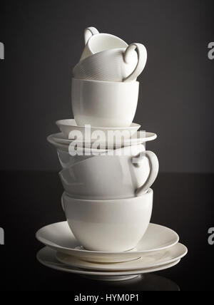 stack of white coffee cups and plates on black background Stock Photo