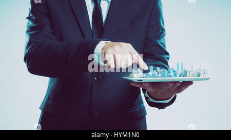 Success businessman using digital tablet show the city skyline on virtual screen , smart and modern city concept . Stock Photo