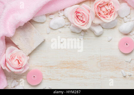 Spa settings with roses. Various items used in spa treatments on white wooden background. Stock Photo