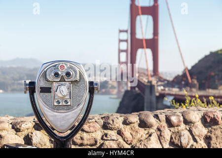 Classic view of coin operated binoculars with famous Golden Gate Bridge in the background on a beautiful sunny day with blue sky and clouds in summer, Stock Photo