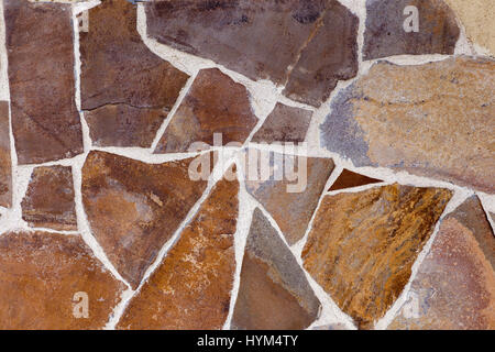 Mosaic collected from decorative stones of various shapes. Stone background. Stock Photo