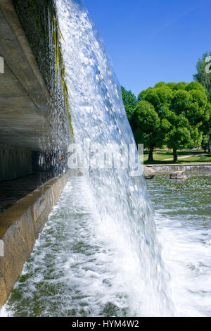 The small waterfall is in summer day on public park Stock Photo