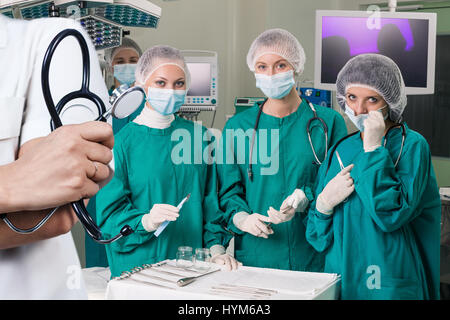 Stethoscope foreground and surgeons team. Stock Photo