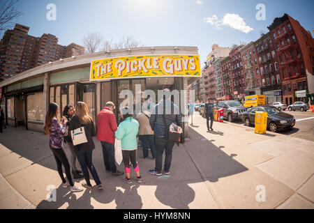 Customers line up outside the Pickle Guys store in the Lower East Side of New York on Sunday, April 2, 2017 to buy freshly ground horseradish and pickles for Passover. Everyone from millennials to former Lower East Sider's descend on the store to buy the freshly ground pungent horseradish to enjoy and to use in Passover seders. The bitter herb brings tears to our eyes and reminds us of the tribulations afflicted on the Jewish people in their flight from Egypt. Passover begins the evening of April 10.  (© Richard B. Levine) Stock Photo