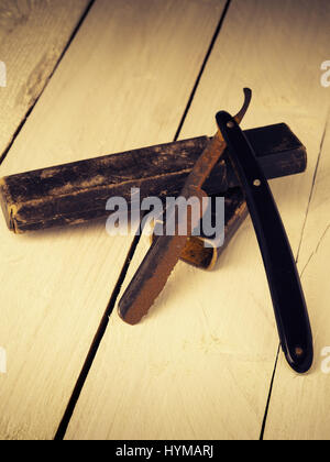 Old and rusty razor on a rustic workbench with space for text or image Stock Photo