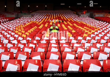 Liverpool fan in the stand reads a match day programme, in the middle of a mosaic dedicated to the anniversary of the Hillsborough disaster, during the Premier League match at Anfield, Liverpool. PRESS ASSOCIATION Photo. Picture date: Wednesday April 5, 2017. Stock Photo
