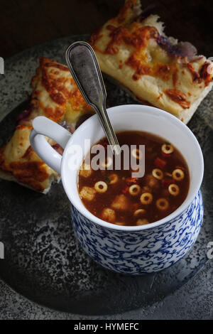A cup of Minestrone soup with mozzarella and red onion focaccia bread shot with low key lighting Stock Photo