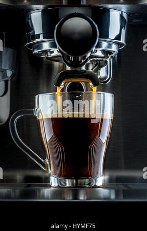 Traditional pump espresso coffee machine pouring shot into transparent glass cup Stock Photo