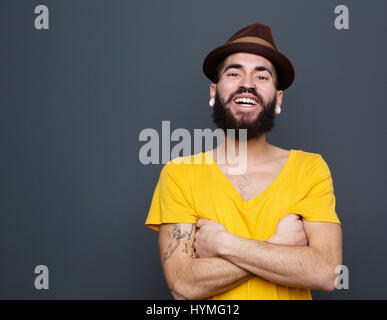 Close up portrait of a cheerful young man with beard laughing on gray background Stock Photo