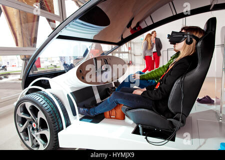 Girl in virtual glasses headset testing Vodafone 5G-based communications systems for vehicles on exhibition Cebit 2017 in Hannover Messe, Germany Stock Photo