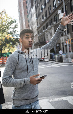 A young, black hipster poses for a candid photograph in NYC. Shot during the autumn of 2016. Stock Photo