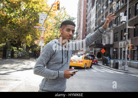 A young, black hipster poses for a candid photograph in NYC. Shot during the autumn of 2016. Stock Photo