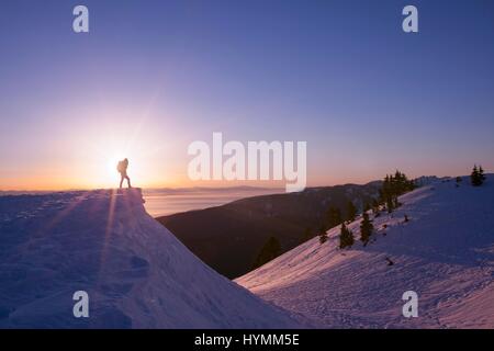 Silhouette of female hiker watching sunset in the background on Mount Seymour, Vancouver, British Columbia, Canada Stock Photo