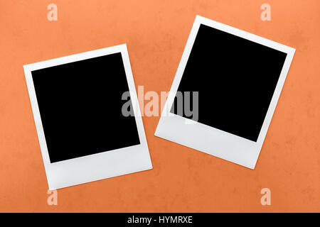 two blank instant camera film frames on orange background. Stock Photo