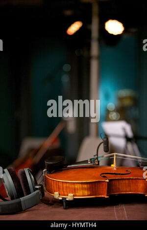 Violin laying on table inside music studio Stock Photo