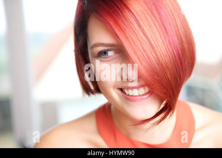 Close up portrait of a cheerful young woman smiling at home Stock Photo
