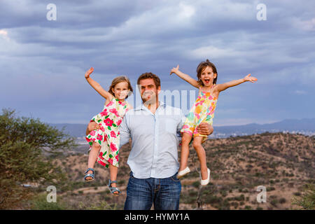 Father holding his two daughters in his arms, Windhoek, Khomas, Namibia Stock Photo