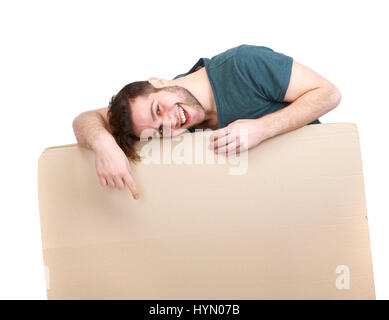 Portrait of a young man smiling and pointing down to blank billboard isolated on white background Stock Photo