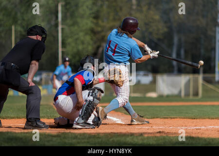Baseball batter hits the ball, ball touching the baseball bat Stock Photo