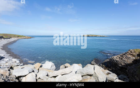Rocky coastline at Moelfre, Anglesey in North Wales with distant view of Moelfre Island (Ynys Moelfre) Stock Photo
