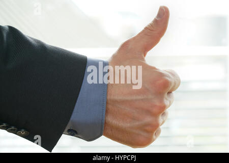 businessman shows thumps up sign for his approval Stock Photo