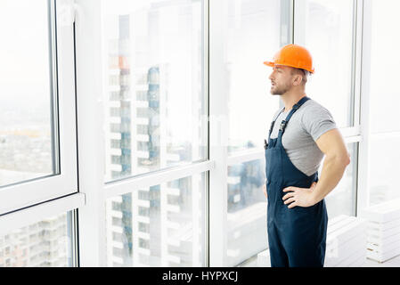 Serious construction engineer standing near window Stock Photo