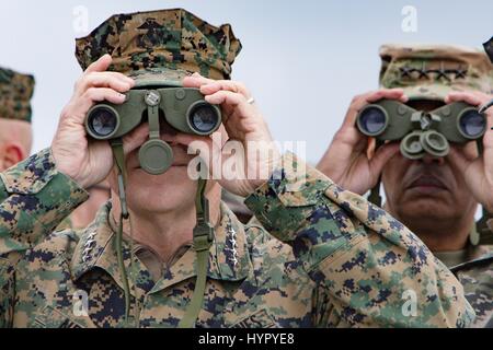 U.S. Marine Corps Commandant Gen. Robert Neller, left, and  Army Gen. Vincent Brooks, U.S. and U.N. Forces Korea commander, watches an amphibious assault demonstration with binoculars during at the annual PALS 2017 exercises April 2, 2017 in Pohang, South Korea. PALS is held annually to help strengthen relationships between Indo-Asia-Pacific region Marine and Naval forces. Stock Photo