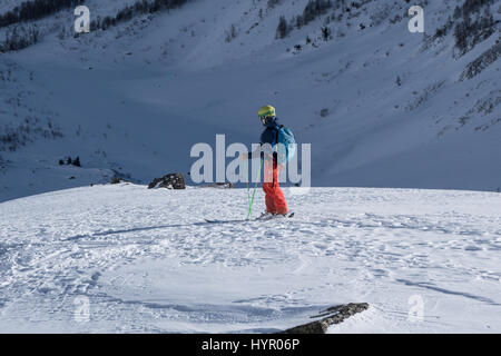Courmayeur, Italy - January 16, 2017: Single skier assessing route choice ahead before sking down into mountain valley Stock Photo