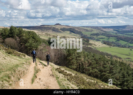 Couple walking on the great ridge from Mam Tor to Lose Hill on a sunny spring day in the Peak District national park, England. Stock Photo