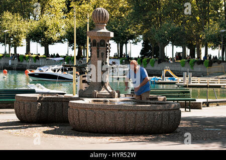 Lausanne, Switzerland - August 26, 2016: Senior person washing hands in the fountain in Lake Geneva in Lausanne, Switzerland Stock Photo